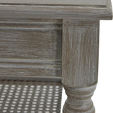 Close-up of Hill Interiors Rattan Coffee Table in brown, showing the distressed wood frame, turned leg detail and woven cane lower shelf.