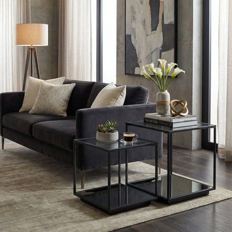 Hill Interiors Harweld black framed glass side tables set of two, nested in a modern living room beside a dark grey velvet sofa.