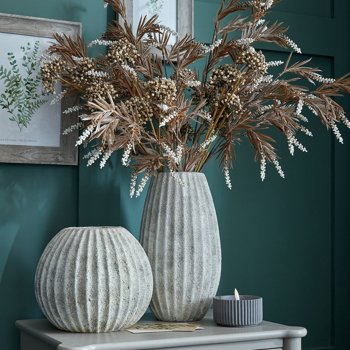 Hill Interiors Round Ceramic Vase in grey with ribbed textured finish, styled with dried foliage stems beside a smaller round vase on a console.