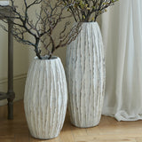 Hill Interiors Tall Ceramic Fin Vase in white, shown as a pair of floor-standing ribbed vessels holding branches beside a console table and curtain.