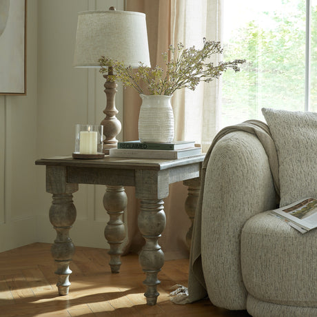 Hill Interiors Wooden Square Side Table 60cm in brown with turned legs, styled beside an armchair with a lamp, vase and books by a sunlit window.