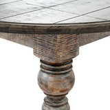Close-up of Hill Interiors Round Wooden Coffee Table in brown, showing planked circular top, apron edge and turned baluster leg with distressed grain finish.