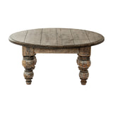 Hill Interiors round wooden coffee table in brown with a planked circular top and four turned baluster legs, shown against a plain white background.