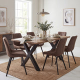 Hill Interiors Live Edge Acacia River Dining Table with black X-shaped metal legs, styled with brown chairs in a bright dining room.