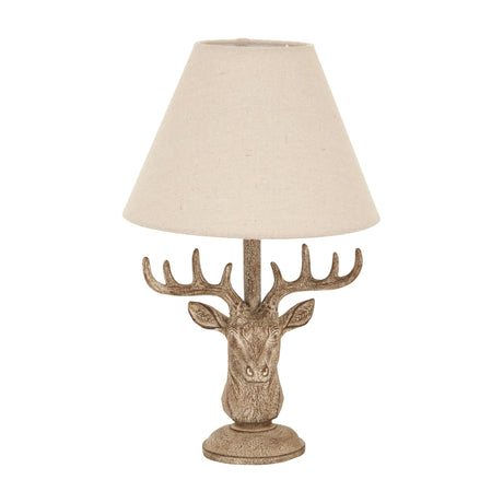 Hill Interiors Stag Head Table Lamp in brown resin with sculpted antlers and a natural linen conical shade, shown on a plain white background.