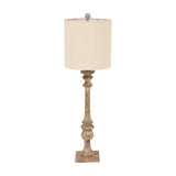 Hill Interiors candlestick table lamp with slender turned brown resin base and natural linen drum shade, shown against a plain white background.