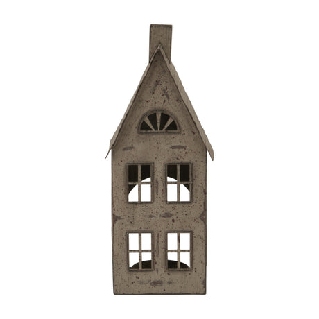 Hill Interiors tall rustic metal house tealight holder in brown, with pitched roof, chimney, arched attic window and cut-out panes, on a white background.