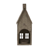 Hill Interiors tall rustic brown metal house tealight holder with pitched roof, chimney, arched opening and cut-out windows, on a plain background.