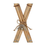 Hill Interiors Large Natural Rustic Crossed Wooden Skis Ornament in beige with silver snowflake details, twine bow and sprig, shown on a white background.
