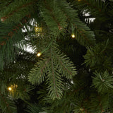 Close-up of Hill Interiors Fir 400L LED Christmas Tree in green, showing dense plastic needle branches with warm white pre-wired LEDs glowing softly.