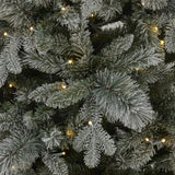 Close-up of Hill Interiors Snowy Forest Fir Christmas tree branches in green plastic with frosted snow tips and warm white LED lights woven through.