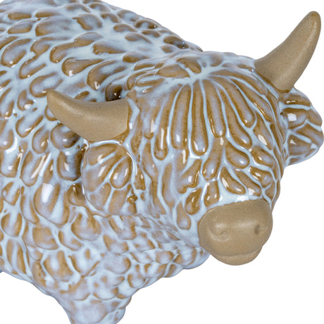 Close-up of Hill Interiors Medium Ceramic Highland Cow Ornament in white glaze, showing textured shaggy coat, tan horns and muzzle.
