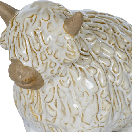 Close-up of the Hill Interiors Ceramic Highland Cow Ornament in white, showing textured shaggy glaze, gentle beige horns and soft muzzle detailing.