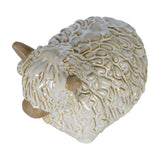 Hill Interiors ceramic Highland cow ornament in white glaze with textured shaggy coat and pale horns, shown from above on a plain background.