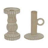 Hill Interiors ceramic pillar candle holders in white, one ribbed baluster form and one slim taper style with ring handle, on a plain background.