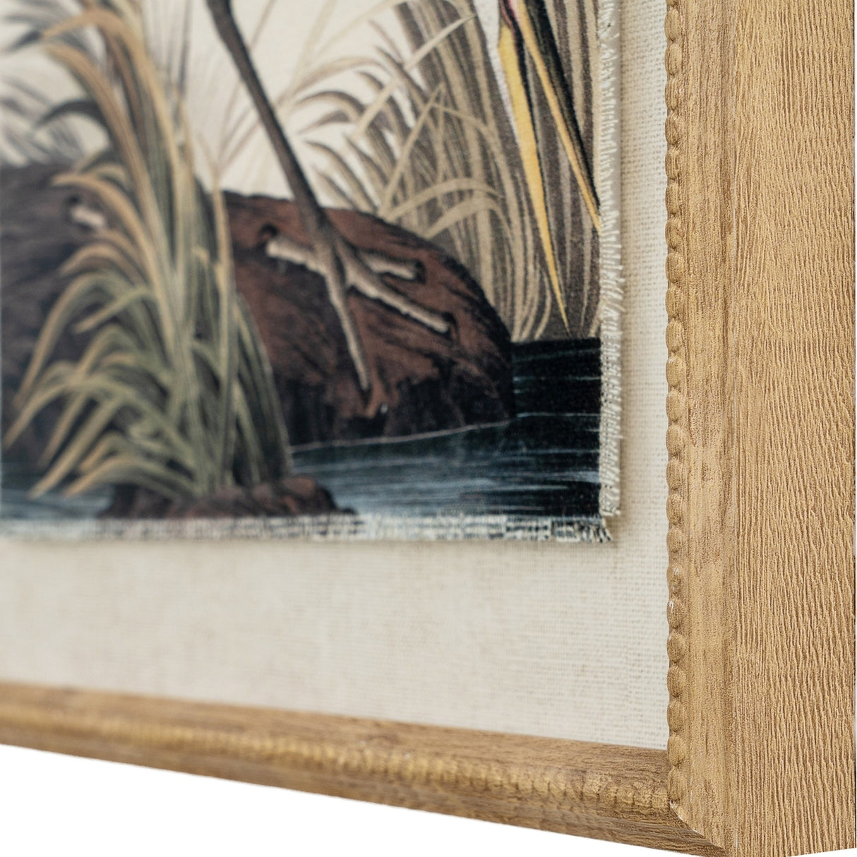 Close-up of Hill Interiors Heron on Linen wall art showing the beaded brown wooden frame edge and printed detail of grasses, water and heron legs.