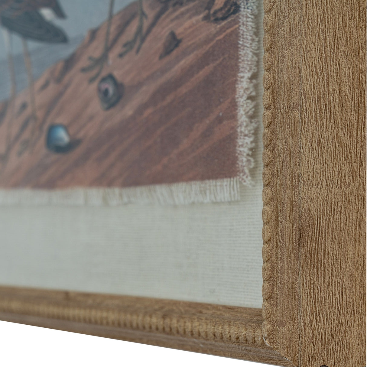 Close-up of the beaded brown frame corner on Hill Interiors Sandpipers wall art, showing the linen-effect print, glass front and textured wooden edge.