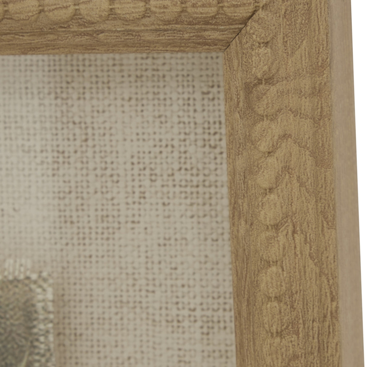 Close-up of the Hill Interiors Avocet on Linen framed wall art, showing the warm brown beaded wood frame corner and natural linen backing behind glass.
