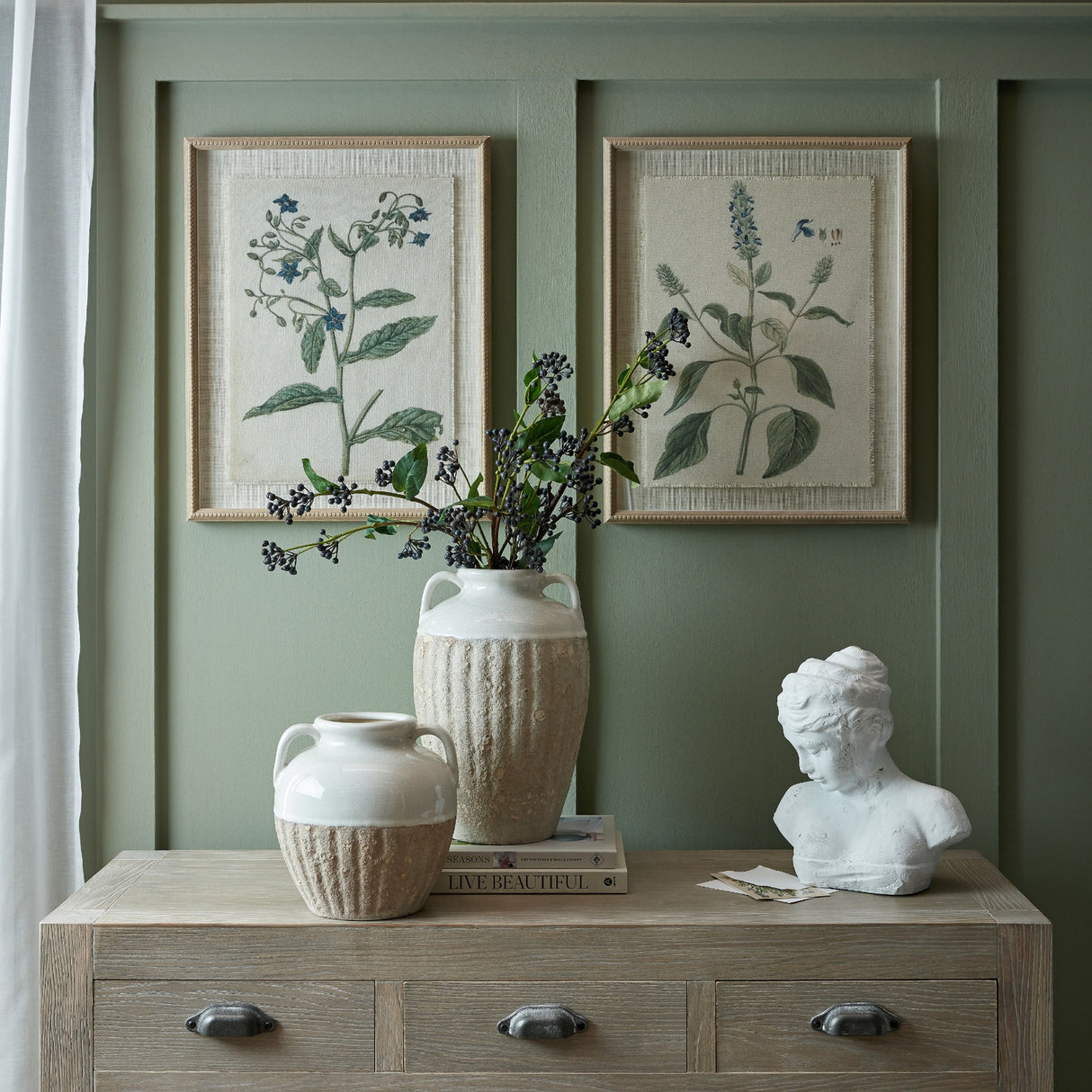 Hill Interiors Salvia on Linen botanical prints in beaded brown frames displayed on a sage panelled wall above a console with ceramic vases and a bust.