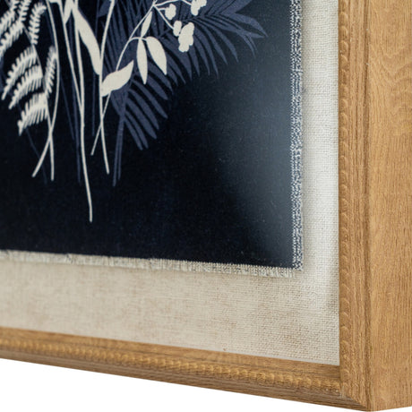 Close-up corner detail of Hill Interiors Meadow on Linen framed wall art, showing white botanical silhouettes on navy with linen mount and beaded wood frame.