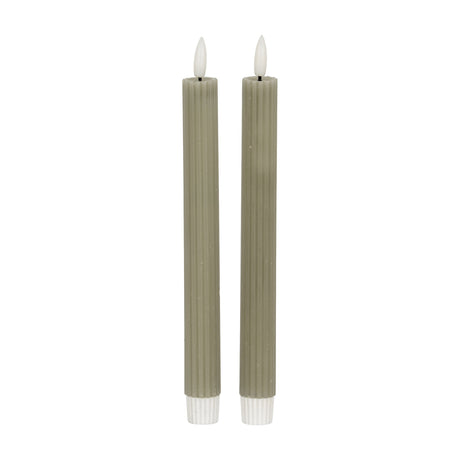 Pair of Hill Interiors Ribbed Taper Candles in sage green wax with fluted surfaces and lit flame tips, shown against a plain white background.