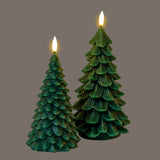 Hill Interiors Natural Glow Tree LED wax candles in green, shaped as stylised fir trees with lit flame-effect tips, shown against a grey background.