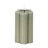 Hill Interiors Natural Glow LED pillar candle in beige with a scalloped flower-shaped body and flickering LED flame, shown on a plain white background.