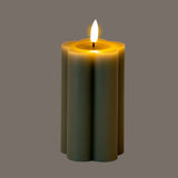 Hill Interiors Natural Glow LED pillar candle in beige with a fluted plastic body and flickering flame effect, shown on a grey background.
