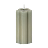 Hill Interiors Natural Glow LED pillar candle in beige with a scalloped flower-shaped profile and moulded flame, shown on a plain white background.