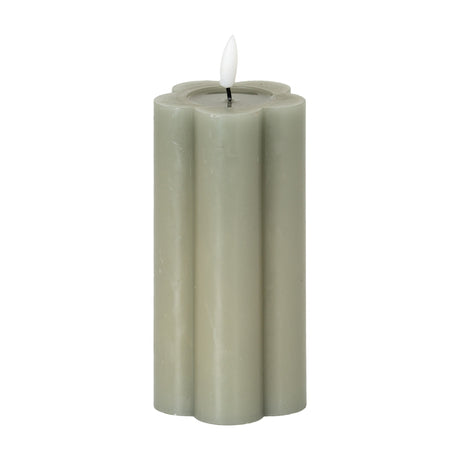 Hill Interiors Natural Glow LED pillar candle in beige with a scalloped flower-shaped profile and moulded flame, shown on a plain white background.