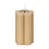 Hill Interiors Natural Glow Stone LED pillar candle in beige with a scalloped flower-shaped body and white flickering LED flame, on a white background.