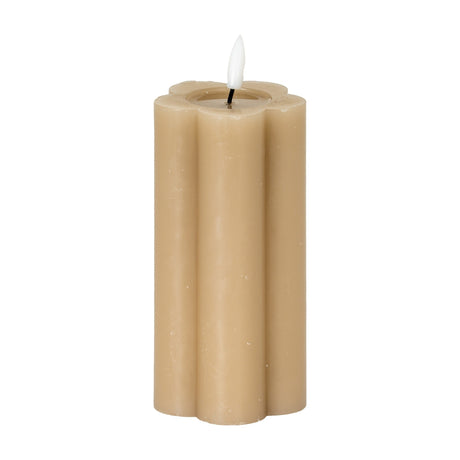 Hill Interiors Natural Glow beige LED pillar candle with a scalloped stone effect body and flickering flame-shaped tip, shown on a plain white background.