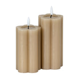Hill Interiors Natural Glow beige LED pillar candles with fluted stone effect finish and amber flame tips, shown as a pair on a plain white background.