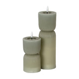 Hill Interiors Natural Glow carved LED pillar candles in beige, shown as a tall and short ribbed pair with flickering flame-effect tips on a white background.