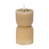 Hill Interiors Stone Carved LED Pillar Candle in beige with ribbed hourglass form and flickering flame-effect tip, shown on a plain white background.