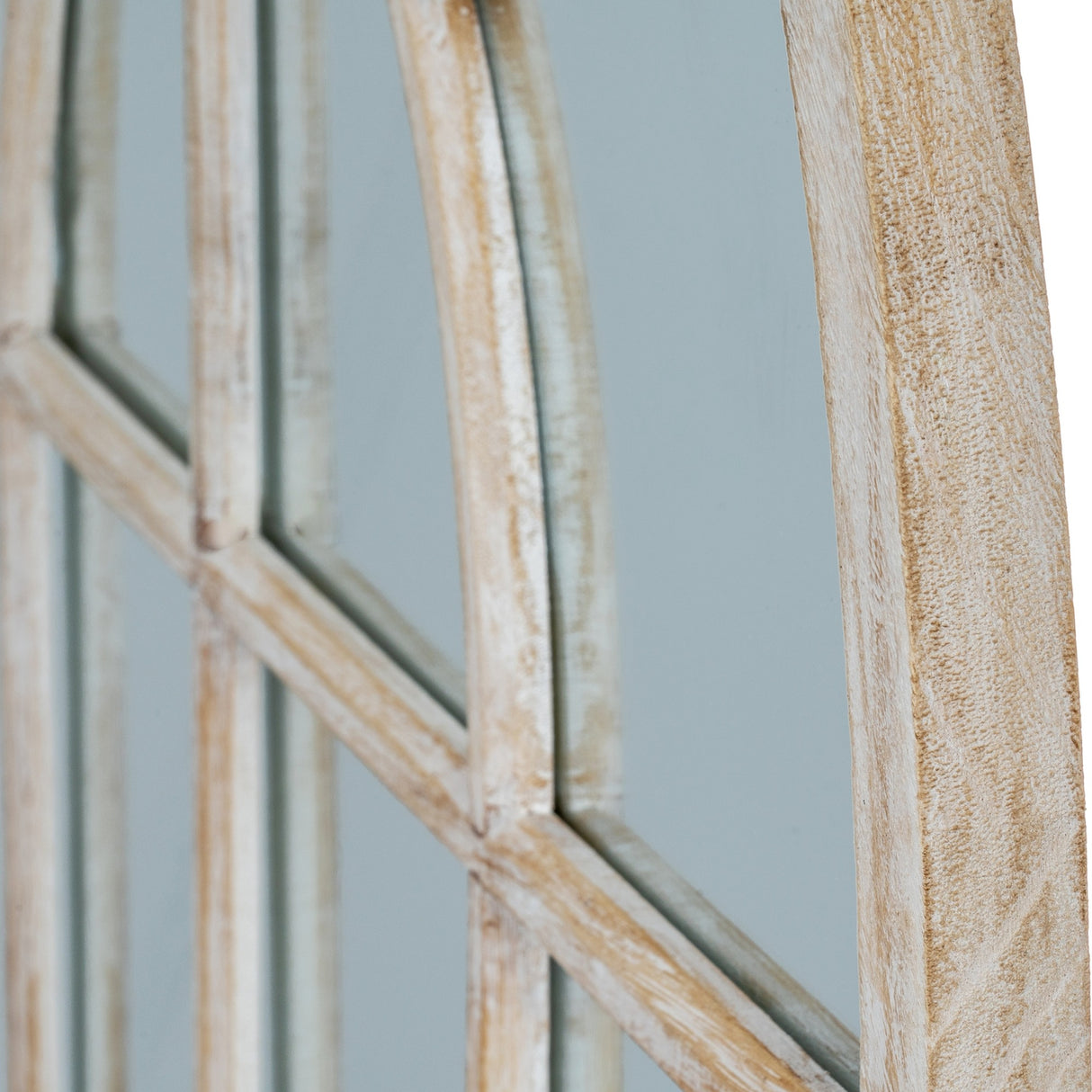 Close-up of Hill Interiors Washed Wood Arched Window Mirror in brown, showing the curved wooden frame edge and pane divisions with visible natural grain.