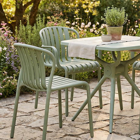 Hill Interiors Moulded Plastic Accent Chairs in French grey with slatted backs and armrests, paired with a matching garden table on a stone patio.