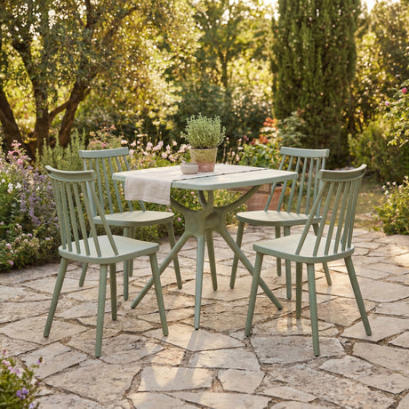Hill Interiors Brolvanic dining set with four green spindle-back plastic chairs around a matching table on a garden stone patio.