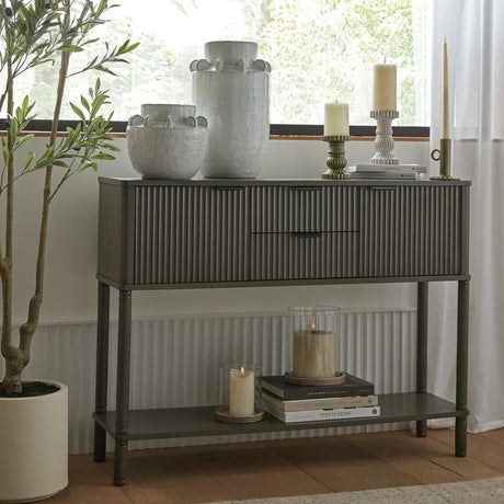 Hill Interiors 2 drawer 2 door wooden console table in brown, styled with ceramic vases, candles and books in a bright window setting.