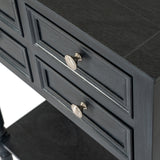 Close-up of the Hill Interiors 4 Drawer Side Table in black wood, showing panelled drawer fronts with round brushed metal knobs and a lower shelf.