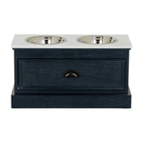 Hill Interiors Wooden Pet Feeder Table in black with white top, two stainless steel bowls, front drawer with cup handle, on a plain background.