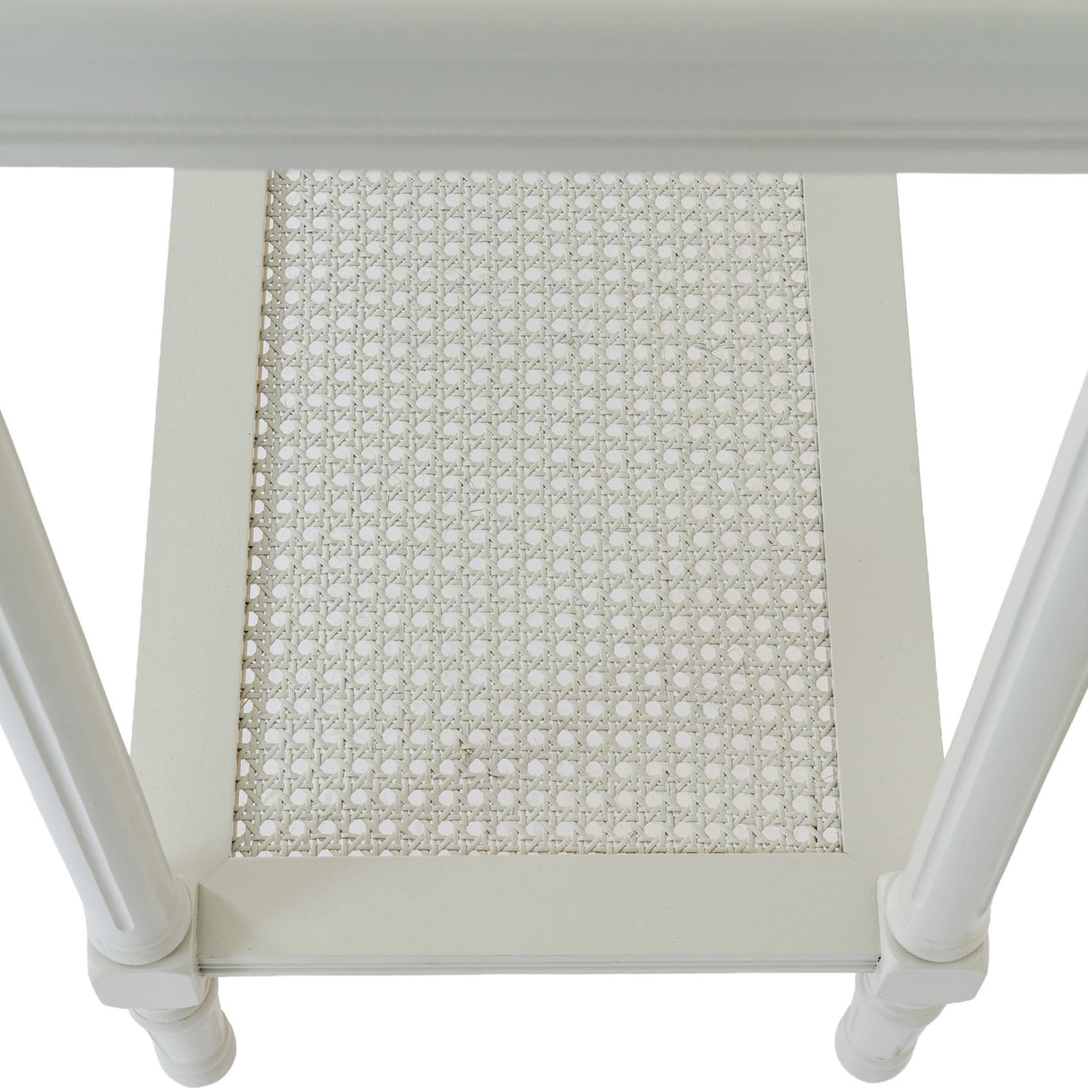 Close-up of Hill Interiors Large Rattan Console Table in white, showing the woven rattan lower shelf panel framed by turned wooden legs.