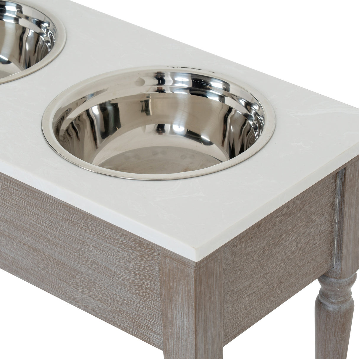 Close-up of the Hill Interiors Wooden Pet Feeder Table in grey, showing two stainless steel bowls set into the pale marbled top above turned wooden legs.
