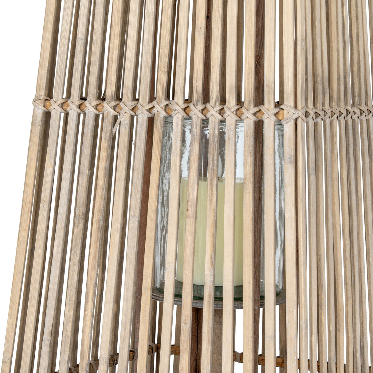 Close-up of the Hill Interiors Large Wicker Lantern in brown, showing the woven rattan frame and removable glass holder with a pillar candle inside.