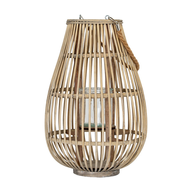 Hill Interiors Medium Ellipse Wicker Lantern in brown with a rounded woven frame, clear glass candle holder inside and rope handle, on a white background.