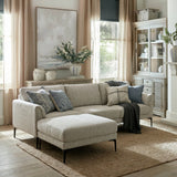 Hill Interiors Vaxeer three seater sofa with matching footstool in white upholstery on black metal legs, styled with blue cushions in a bright living room.