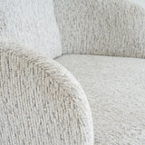 Close-up of the Hill Interiors Marlenza Swivel Accent Chair showing textured white and grey bouclé upholstery on the rounded arm, backrest, and seat.