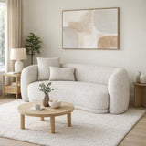 Hill Interiors Marlenza two seater sofa in white bouclé with curved arms and scatter cushions, styled in a neutral living room with round wooden coffee table.