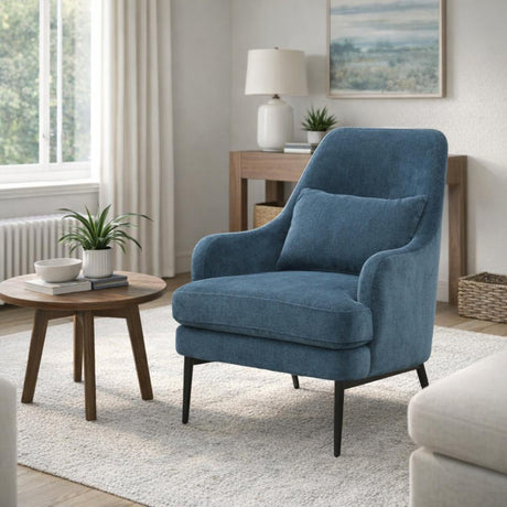 Hill Interiors blue wingback armchair with high curved back, matching cushion and slim black metal legs, styled in a bright living room with side table.