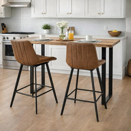 Two Hill Interiors Draxinby tan brown upholstered swivel bar stools with channel-stitched backs and black metal legs at a wood kitchen island.